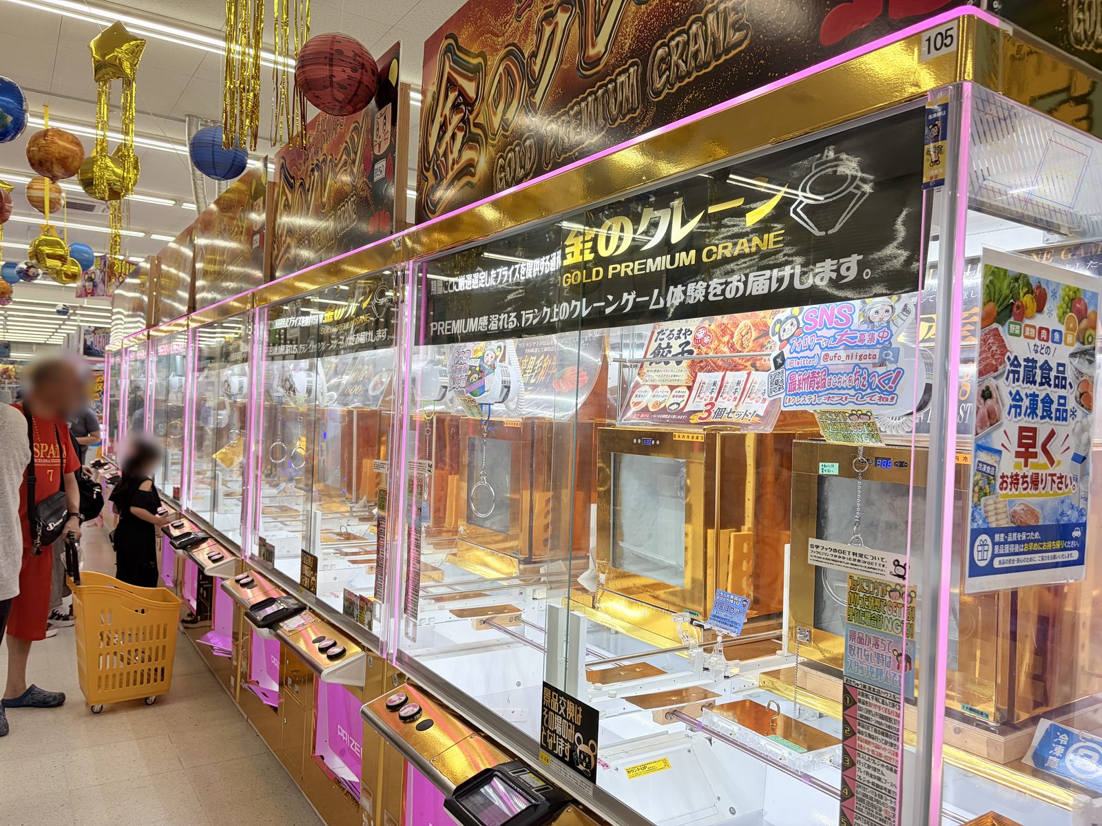 おたちゅう新潟本店の「金のクレーン」コーナー。金色の装飾の台が並び、冷蔵食品・冷凍食品を早めに持ち帰るよう呼びかける掲示が貼られている